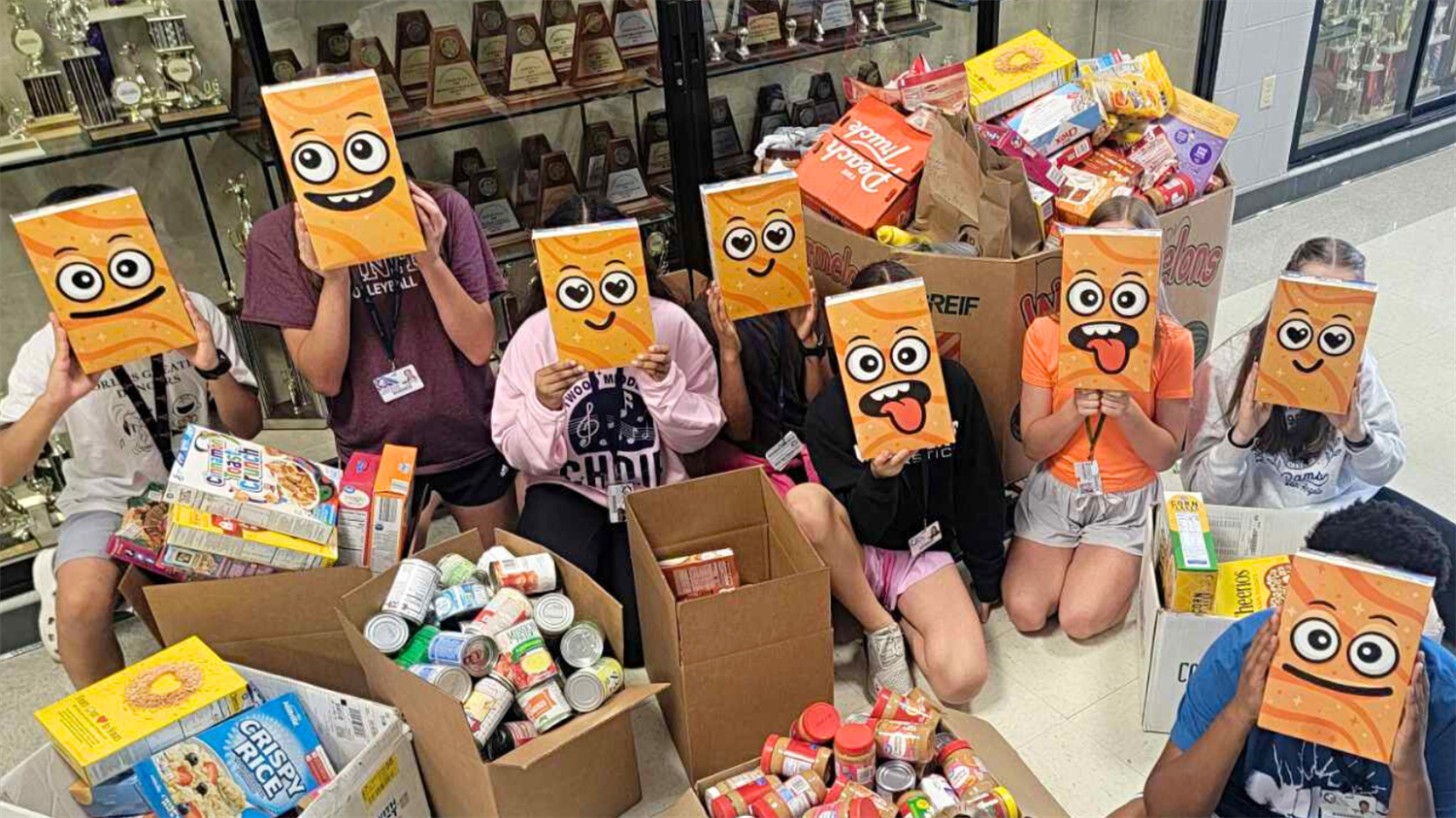 Students pose with collected food donations for Lewisville ISD's 2024 Stuff the Pantry Food Drive. 